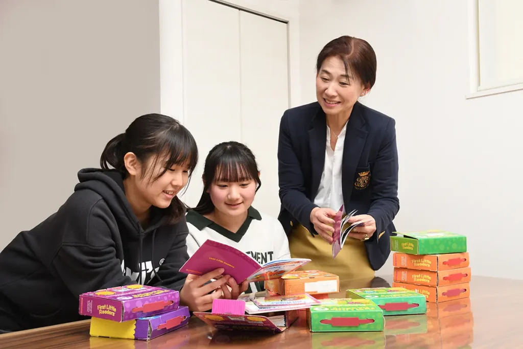 小学校で英語が苦手と感じたお子さんに勉強方法を教える様子の写真